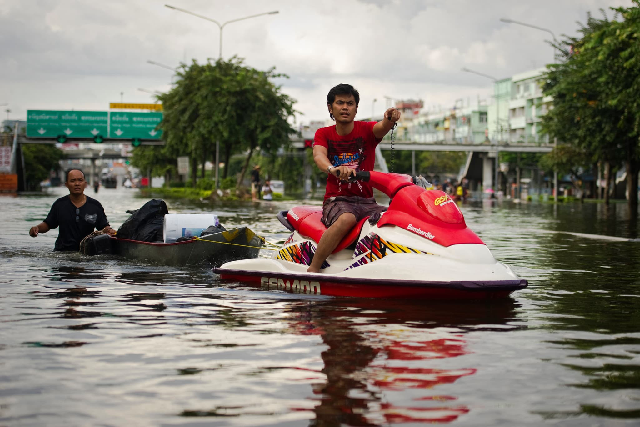 Inondations en Thaïlande: Un homme surfe en jet-ski dans les rues inondées de Bangkok